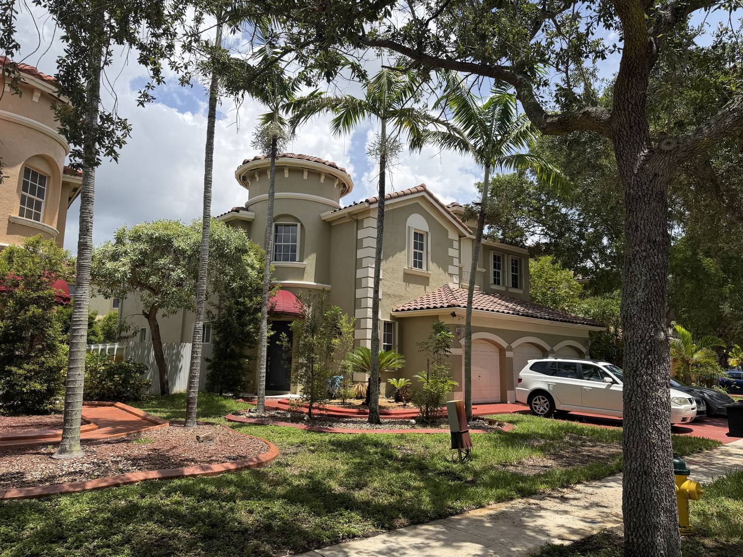 Mediterranean executive home with a rounded turret entry, barrel tile roof and mature royal palms in Miramar, Florida 33027